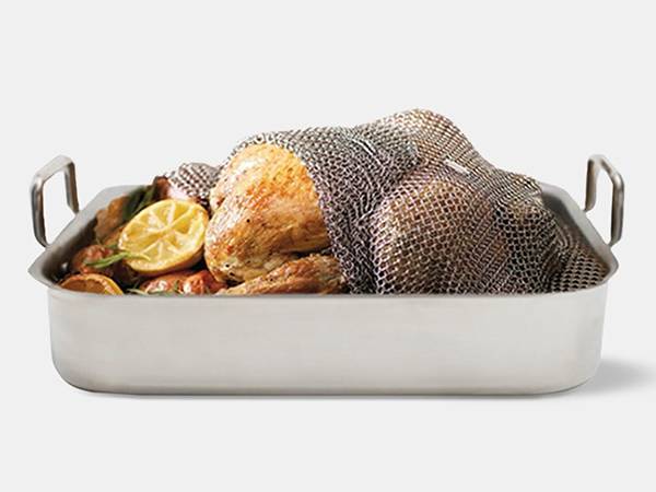 A roasted chicken is covered with stainless steel chainmail sheet.