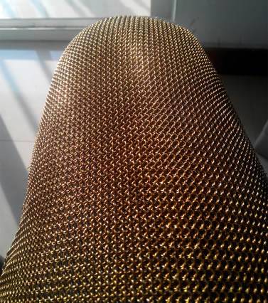 The upper leg part of chainmail chausses with shiny surface under the sunlight.