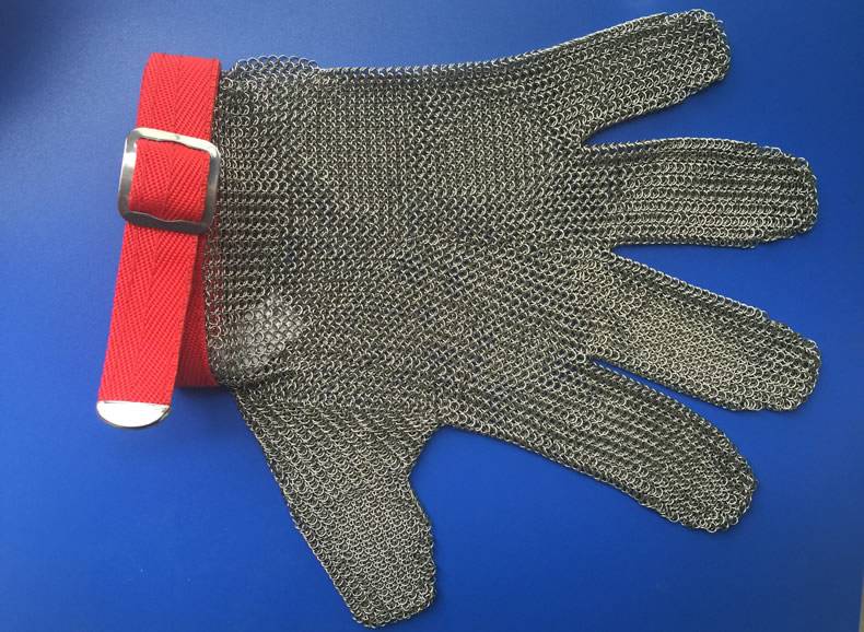 A piece of fiver finger style chainmail glove with red fasten strap is on the blue board.